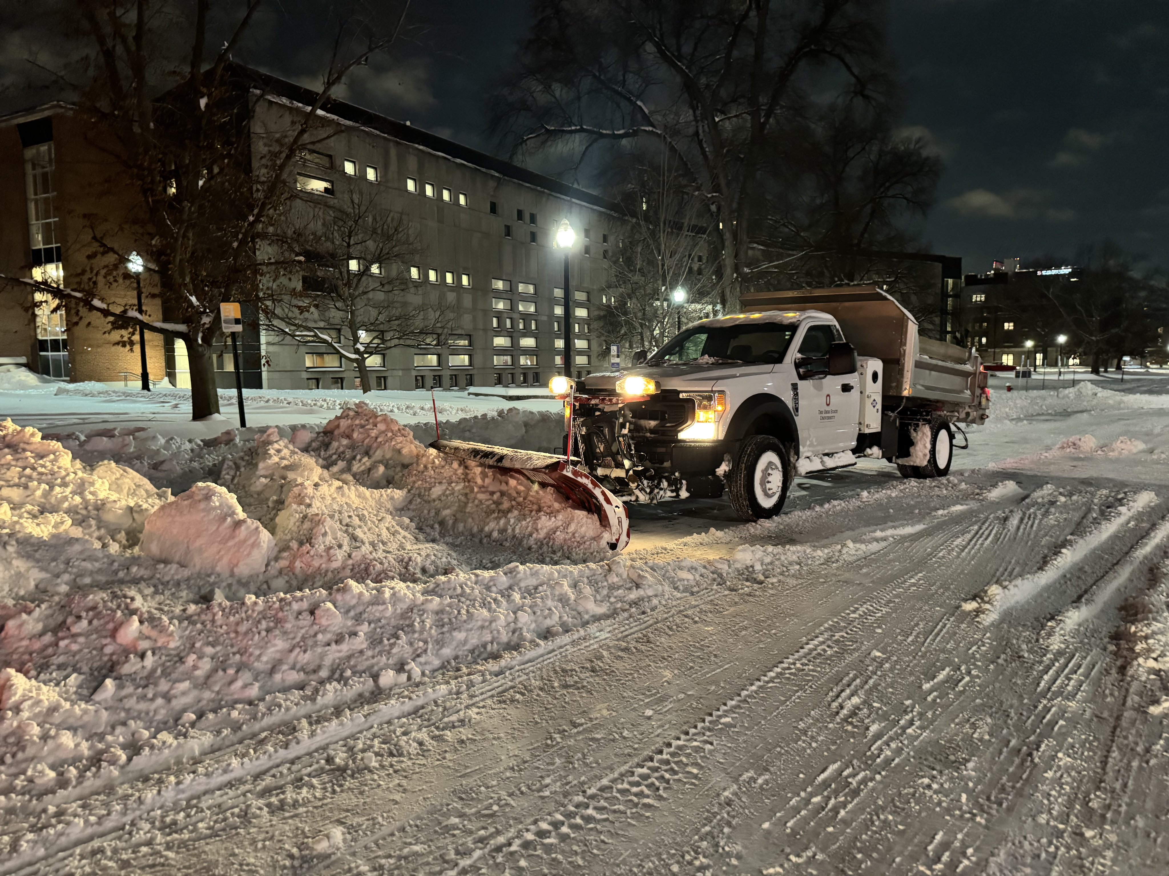 An FOD snow plow plows snow during a winter storm on campus.
