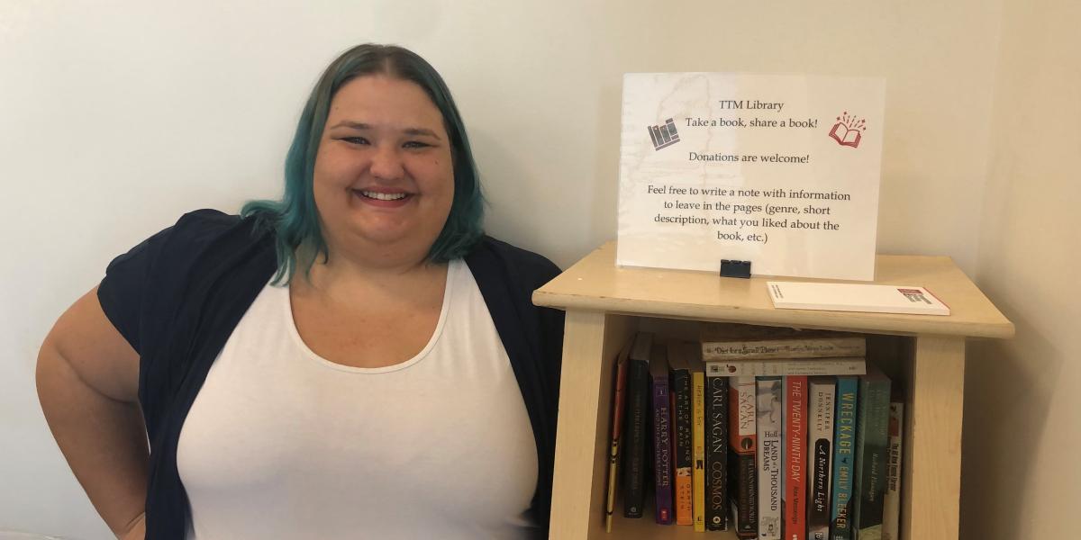 Christy Miller standing next to a book shelf.