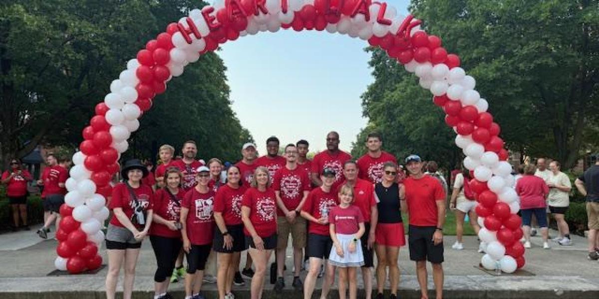 people standing underneath balloon arch