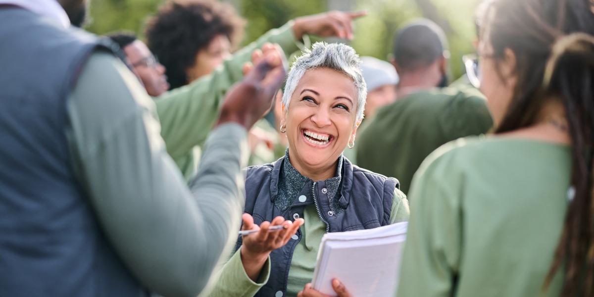 person with clipboard smiling and helping other people