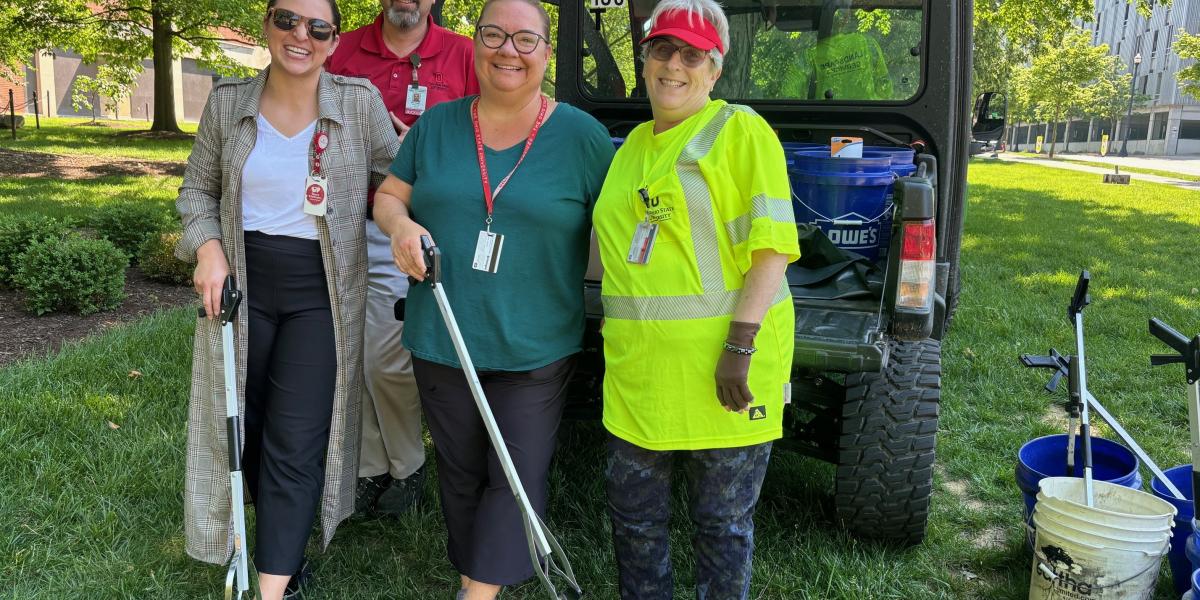 group of people standing with litter grabbers