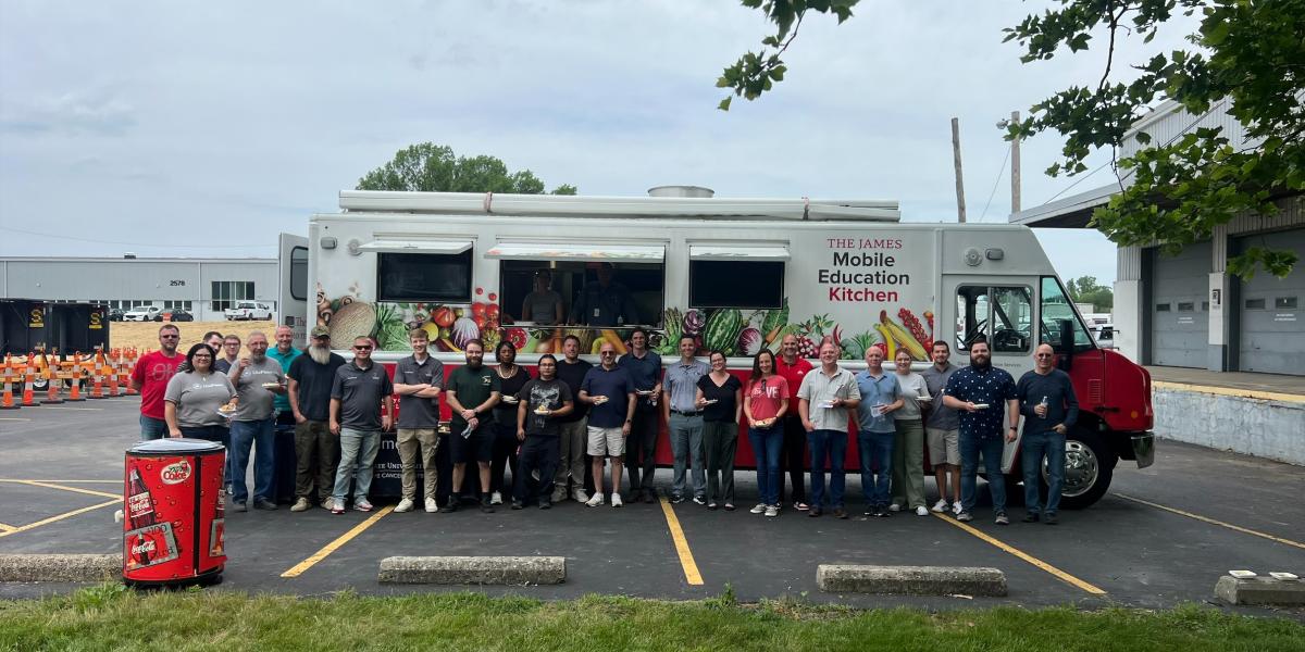 group of people standing in front of truck