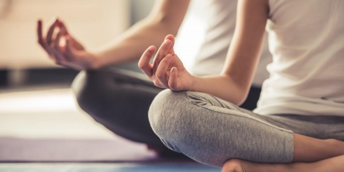 two people sitting in yoga poses