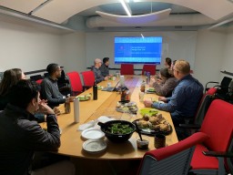group in conference room looking at screen eating balanced lunch
