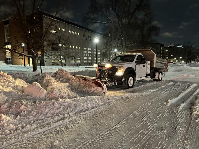 An FOD snow plow plows snow during a winter storm on campus.