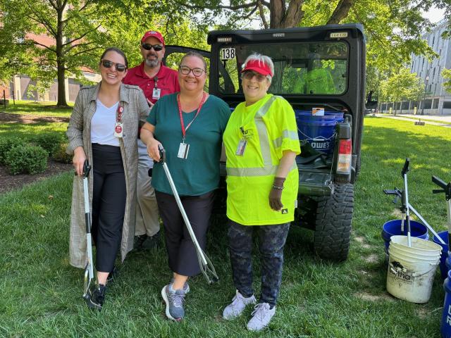 group of people standing with litter grabbers
