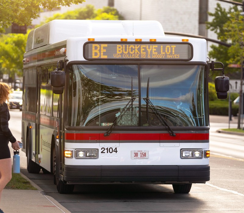An Ohio State University campus bus pulling up to a bus shelter